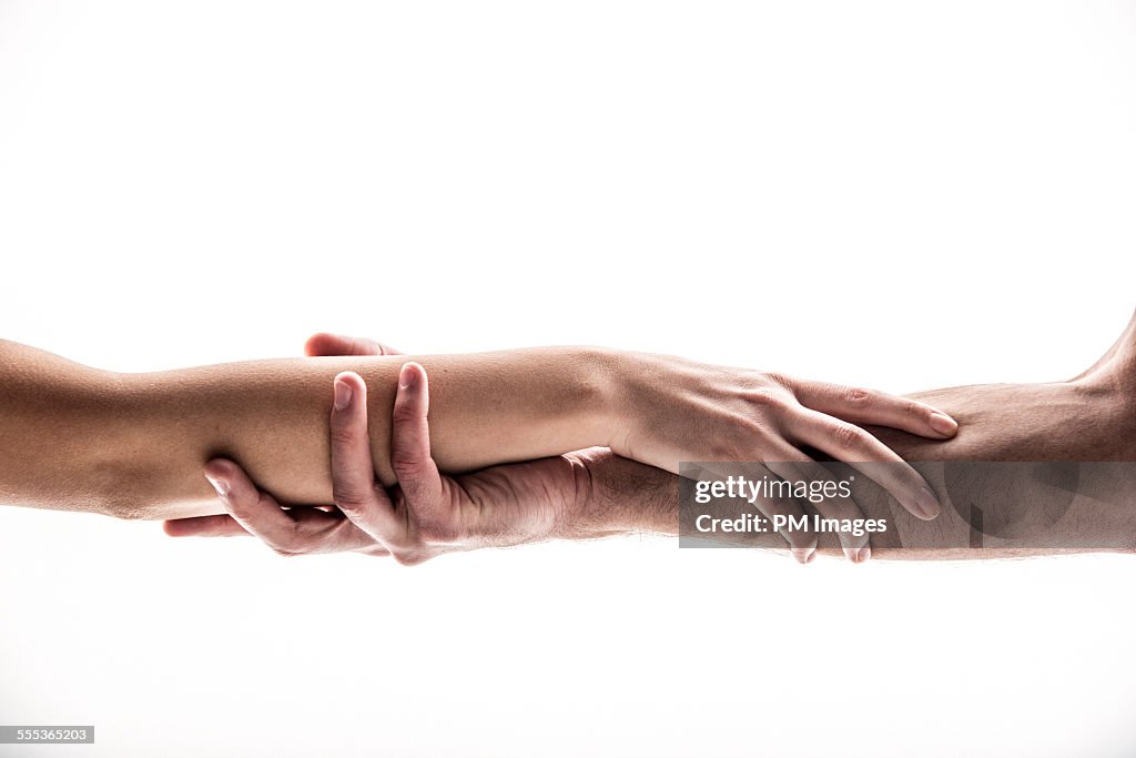 Hands holding forearms