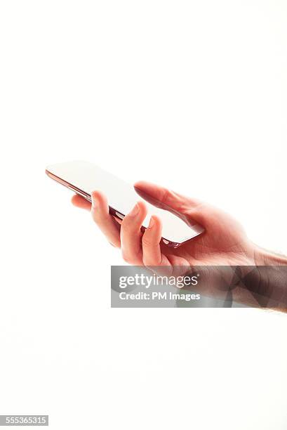 man's hand holding smart phone - high key stock pictures, royalty-free photos & images