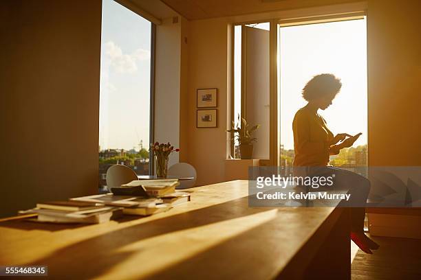 40's couple in apartment - back lit home stock pictures, royalty-free photos & images
