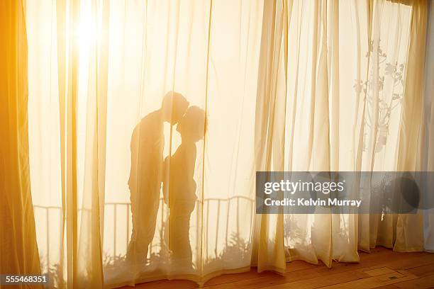 40's couple in apartment - window curtains stock pictures, royalty-free photos & images