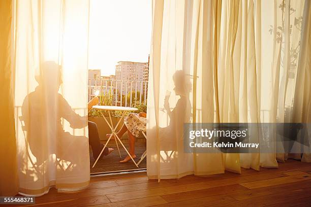 40's couple in apartment - couple balcony stock-fotos und bilder