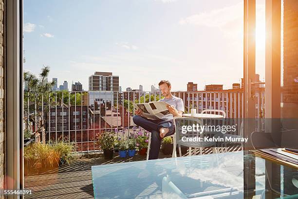 40's couple in apartment - balcony reading stock pictures, royalty-free photos & images