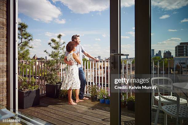 40's couple in apartment - couple balcony stock-fotos und bilder