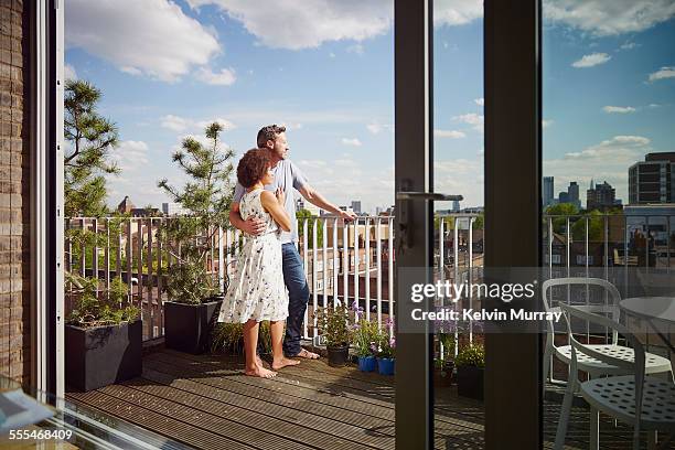 40's couple in apartment - modern apartment balcony stockfoto's en -beelden