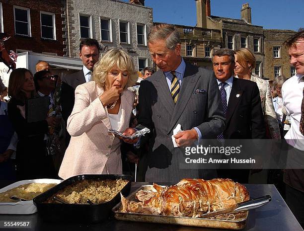 Prince Charles, the Prince of Wales and Camilla, the Duchess of Cornwall visit a roast pork stall in Richmond market on September 14, 2005 in North...