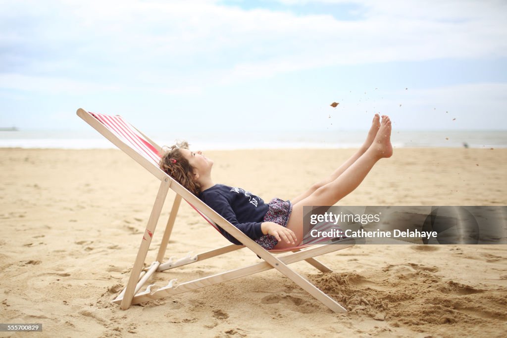 A girl on a deckchair on the beach