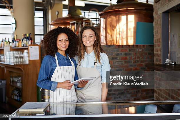 two waiters holding tablet at restaurant - hostesses stockfoto's en -beelden