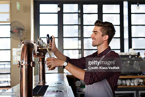 bartender pouring beer at microbrewery - beer taps bildbanksfoton och bilder