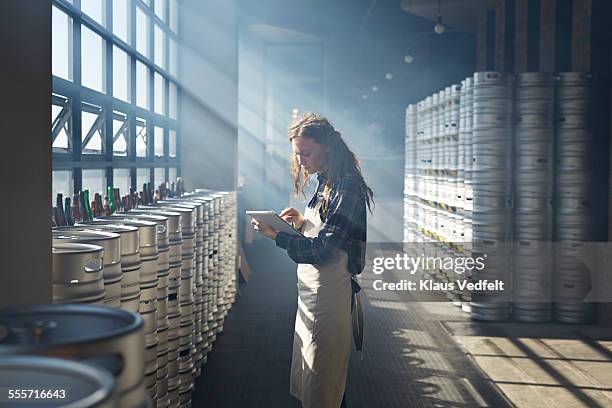 female waiter counting beer keg's using tablet - barrels ストックフォトと画像