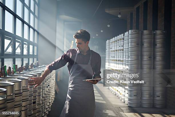 bartender counting beer keg's and using tablet - mestiere nella ristorazione foto e immagini stock