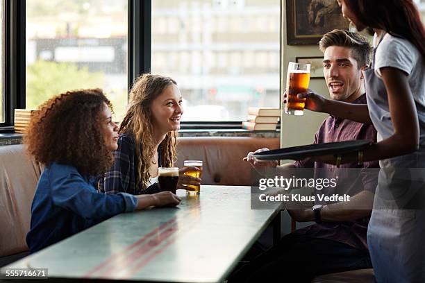waitress serving beer for a group of friends - waitress booth stock pictures, royalty-free photos & images