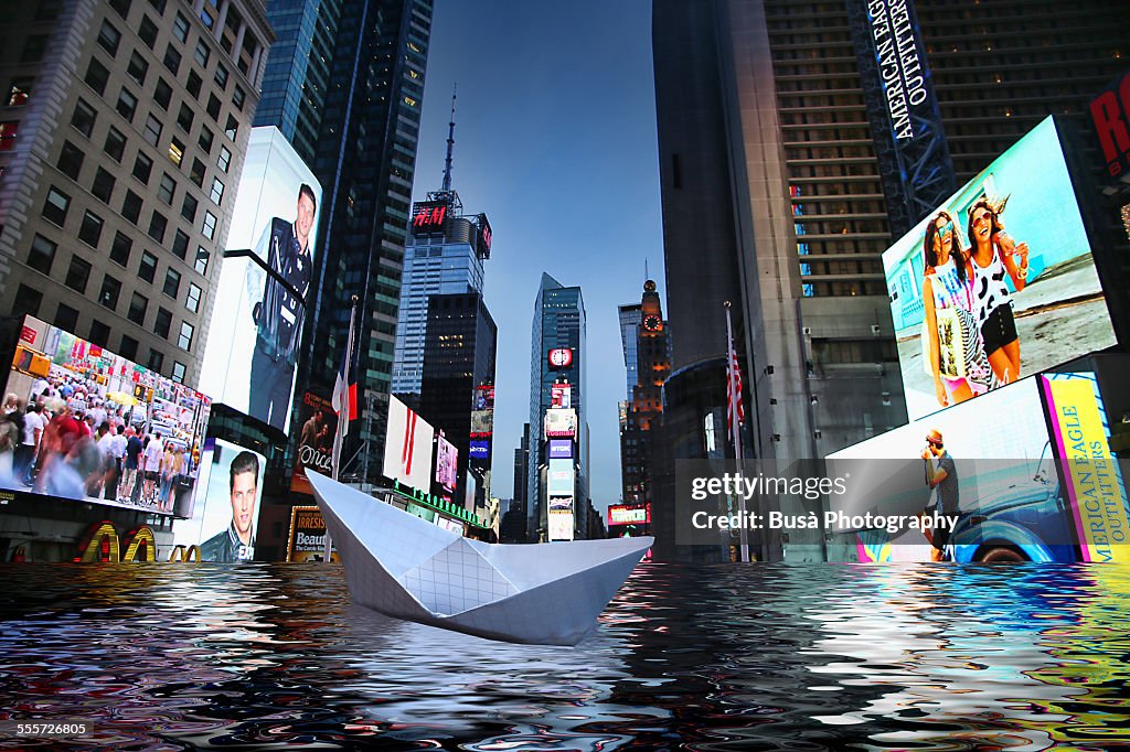 Paper boat floating in a flooded Times Square, NYC