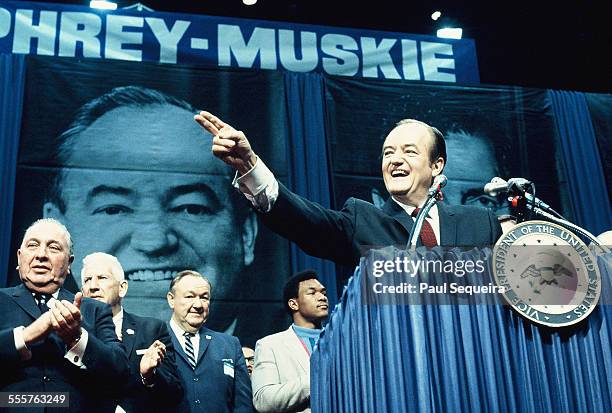 Chicago mayor Richard Daley, far left, applauds as Democratic presidential candidate Hubert Humphrey, on the podium, acknowledges his supporters...