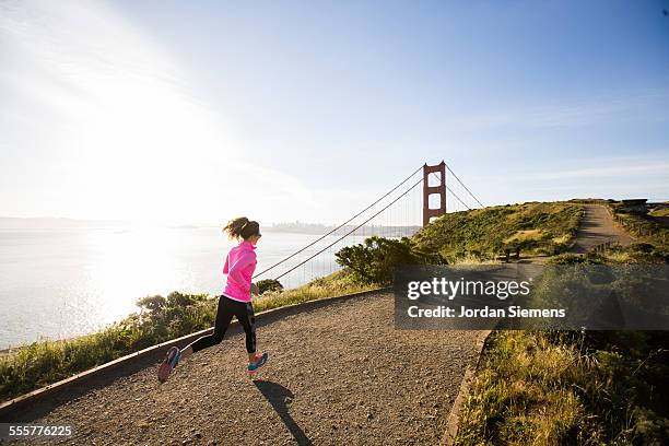 a female trail running near the golden gate - suspension training stockfoto's en -beelden