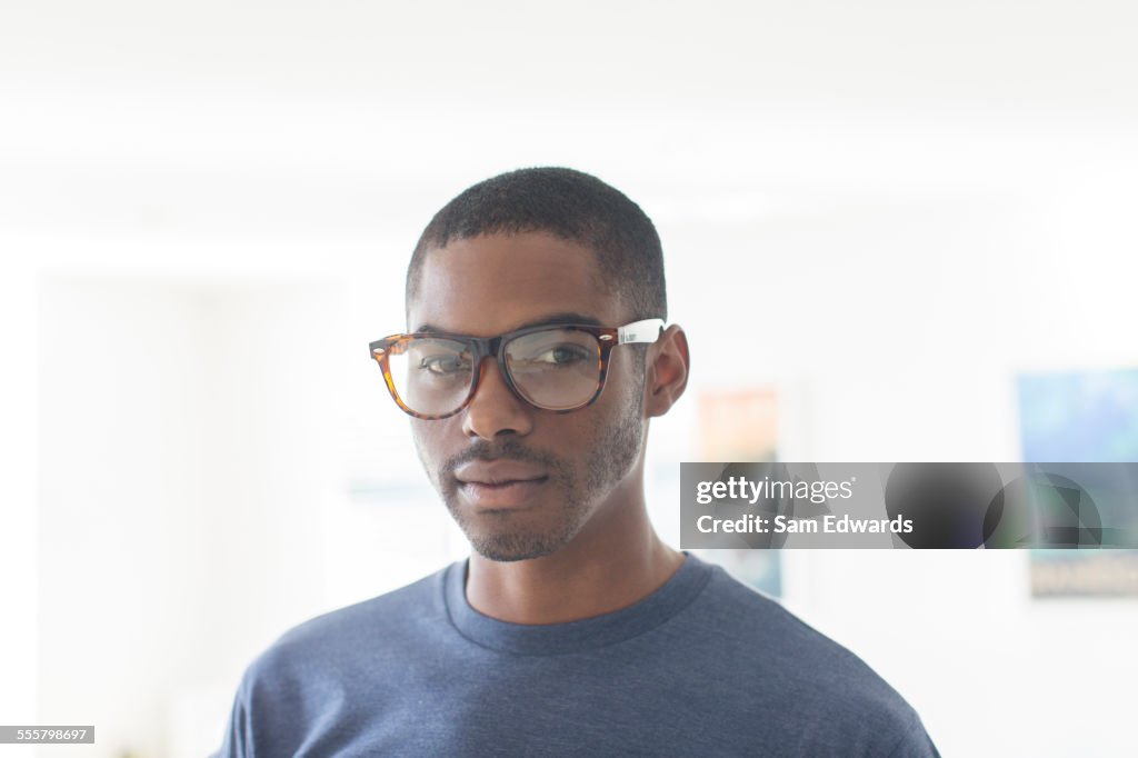 Portrait of young businessman wearing glasses standing in office