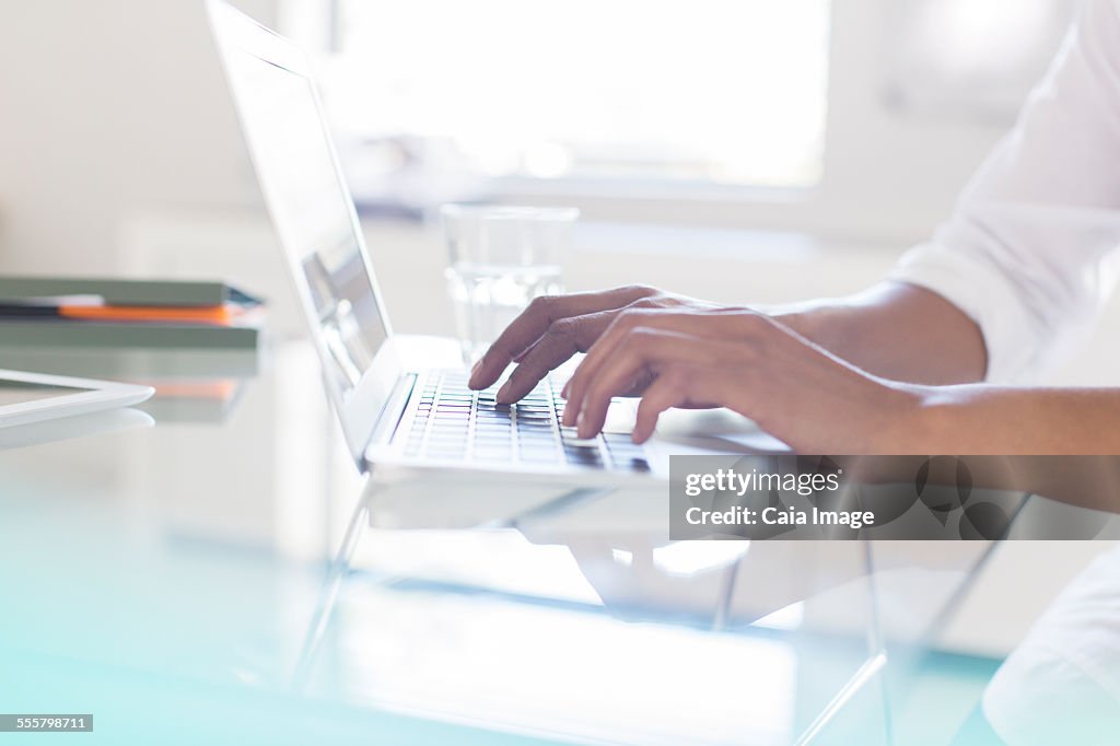 Hands of businesswoman typing on laptop in office