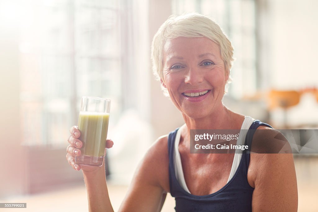 Smiling older woman drinking juice