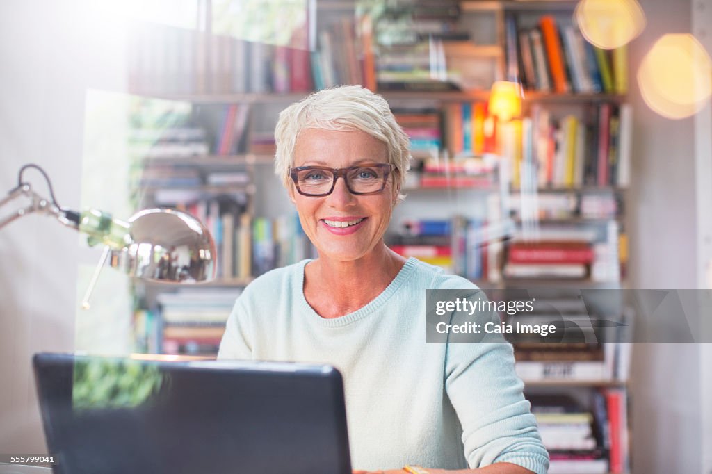 Businesswoman smiling at computer in home office