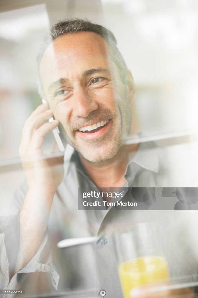 Older man talking on cell phone at breakfast