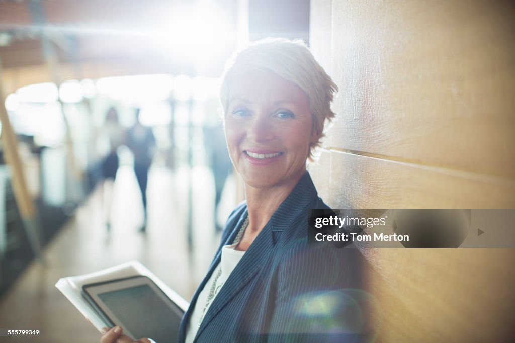 Businesswoman carrying digital tablet in office