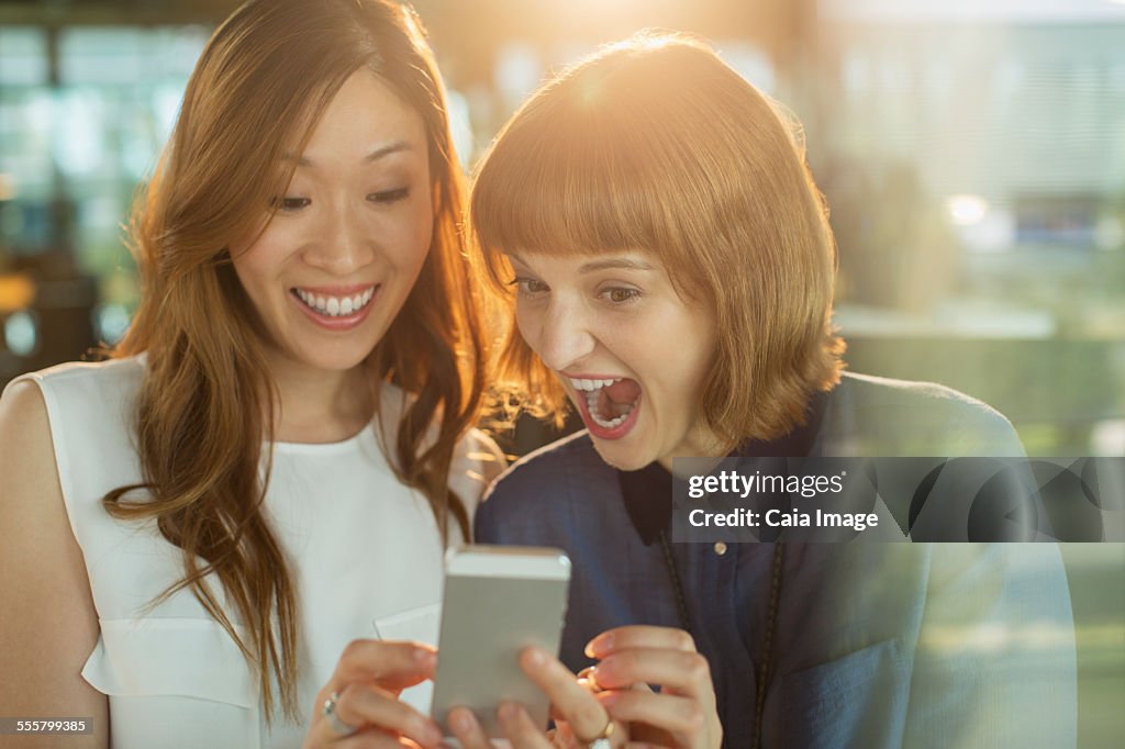 Businesswomen using cell phone in office