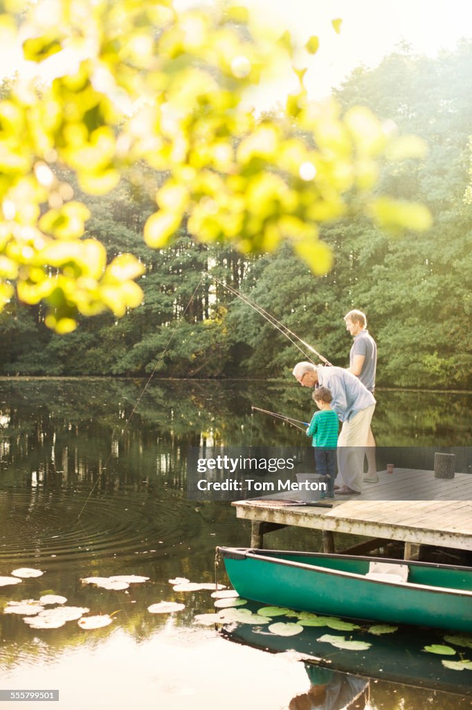 Boy, father and grandfather fishing in lake