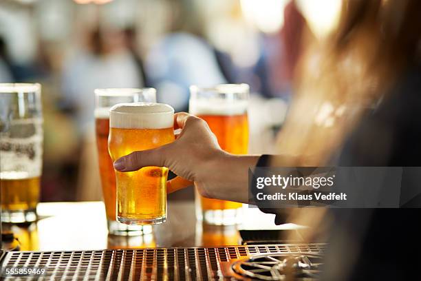 close-up of bartender serving beers at bar - microbrewery stock pictures, royalty-free photos & images