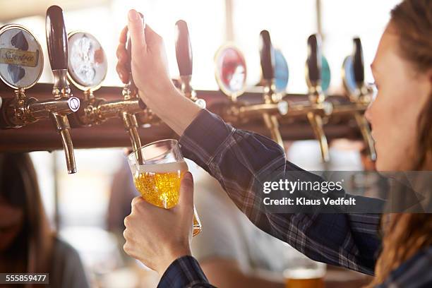 bartender making cask beer at bar - beer pump stock pictures, royalty-free photos & images