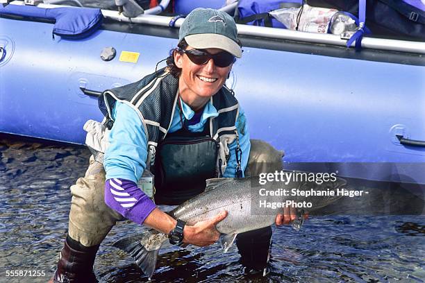 woman holding silver salmon - releasing fish stock pictures, royalty-free photos & images