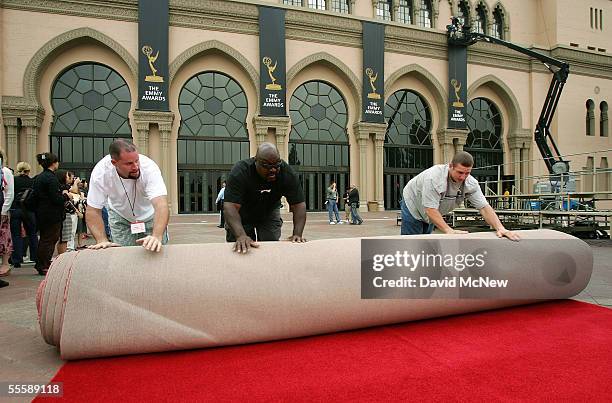 Workers roll and unroll a piece of the red carpet in a mock demonstration for reporters of the rolling out of the red carpet which will be laid in...