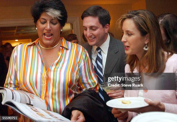 Tammy Haddad, Philippe Reimes and Betsy Fischer check out the premiere issue of Capitol File magazine September 14, 2005 at the magazine's cover...