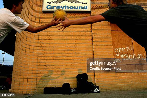Keith Naylor and friend and fellow roofer Kevin Wickersham play a game with a ball after disembarking a Greyhound bus from Texas while they wait for...