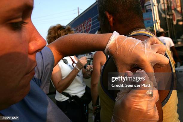 Christy Fountain, a nurse with our Lady of Fatima Church, gives a resident a tetanus shot September 15, 2005 in Biloxi, Mississippi. Thousands of...