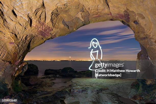 light painting of girl by seashore cave - baie de studland photos et images de collection