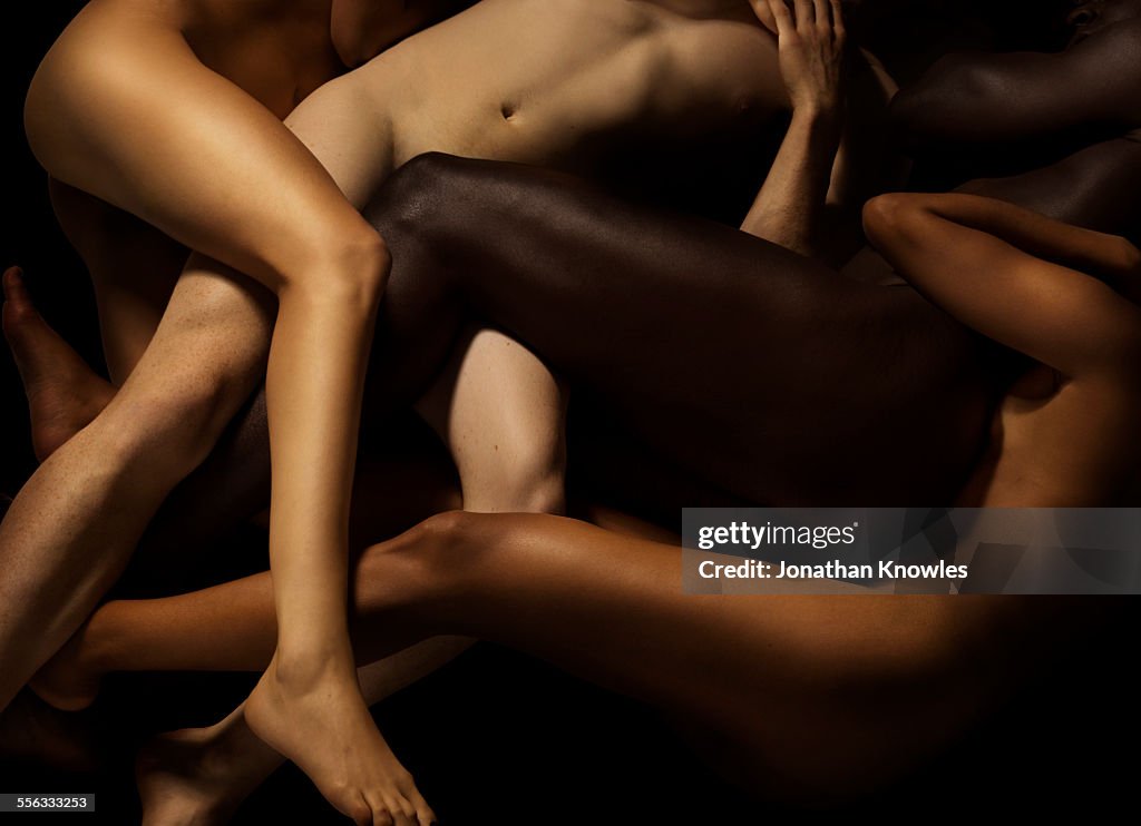 Tangled human bodies of different skin colours