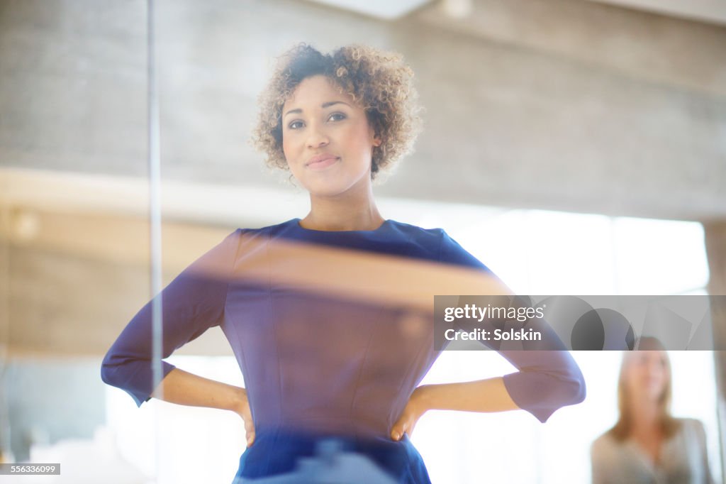 Woman in office looking through glass wall