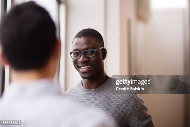 two men in conversation in office - black man working stockfoto's en -beelden