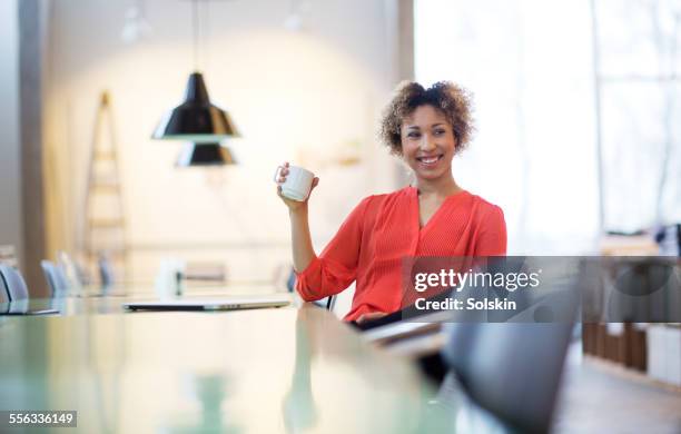 woman in office taking a break, drinking coffee - denmark people happy stock pictures, royalty-free photos & images