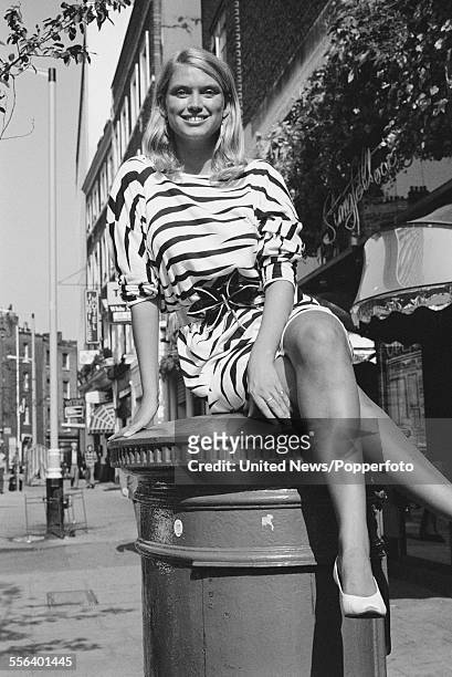 British television presenter on the game show 'Treasure Hunt', Anneka Rice pictured sitting on top of a postbox on Upper St Martins Lane in London on...