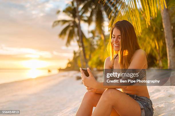 young woman using smartphone on anda beach, bohol province, philippines - foraging on beach stock pictures, royalty-free photos & images