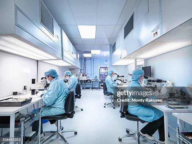 electronics workers in clean room assembling electronic components - semiconductor stock-fotos und bilder