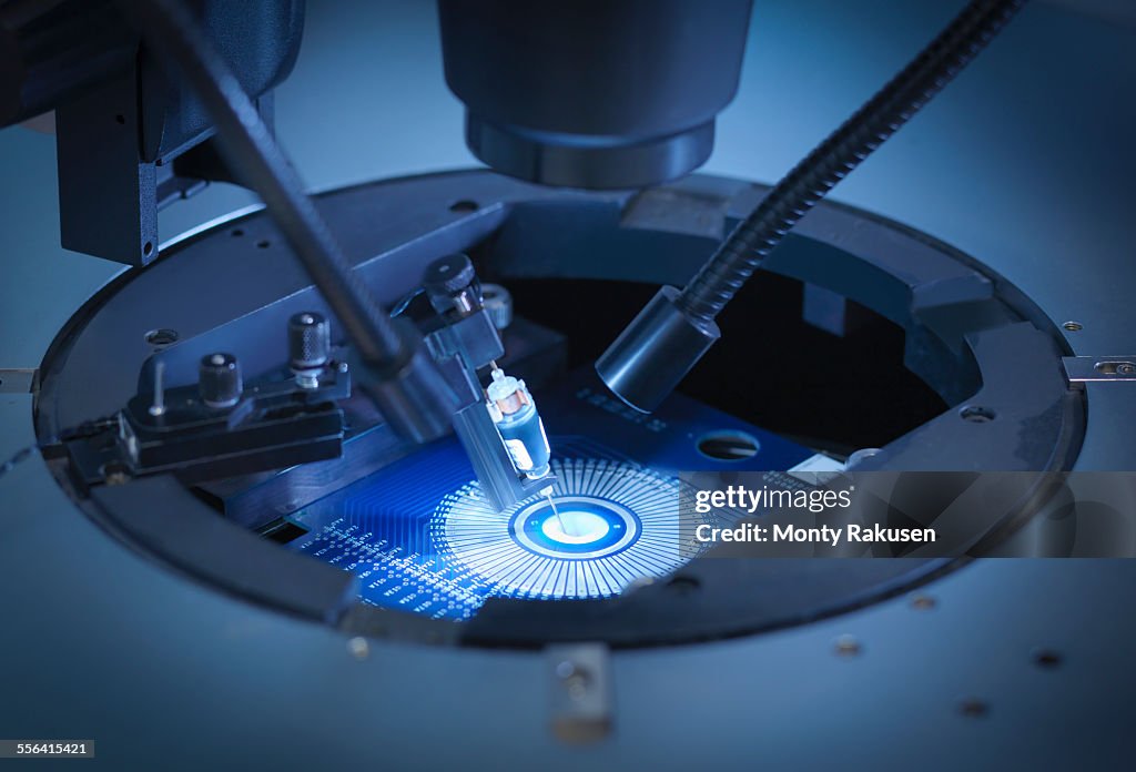 Machine checking silicon wafers in clean room laboratory, close up
