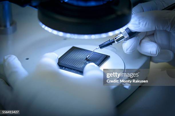 electronics worker checking small electronic chips in clean room laboratory, close up - chip fabrik stock-fotos und bilder