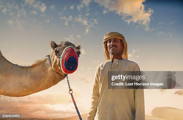 portrait of camel and bedouin in desert, dubai, united arab emirates - beduino fotografías e imágenes de stock