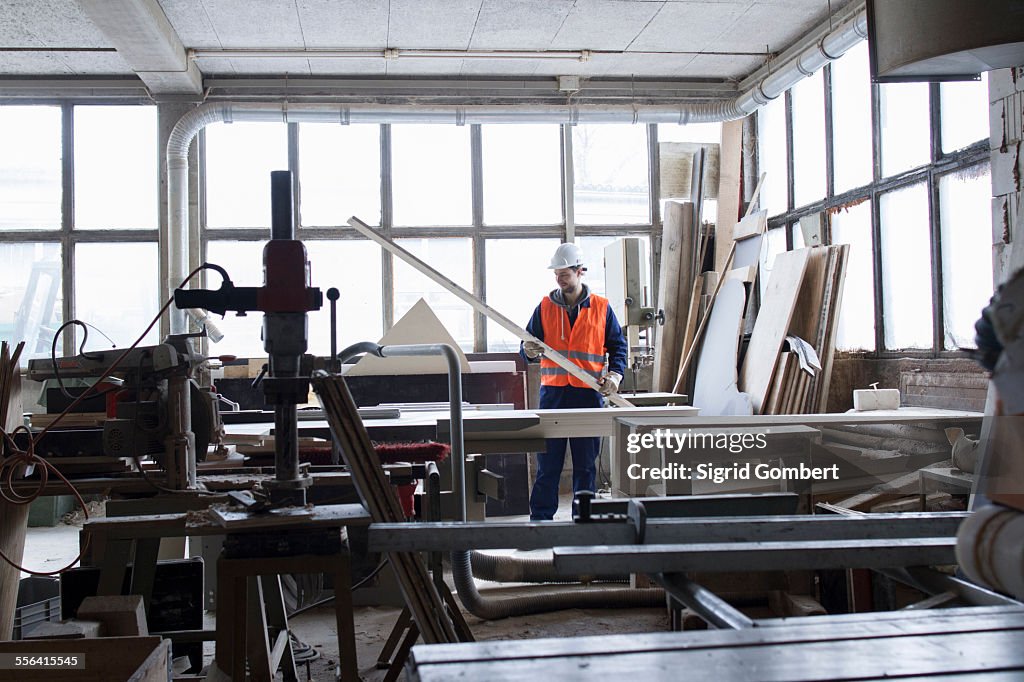 Factory worker examining steel rod at concrete reinforcement factory