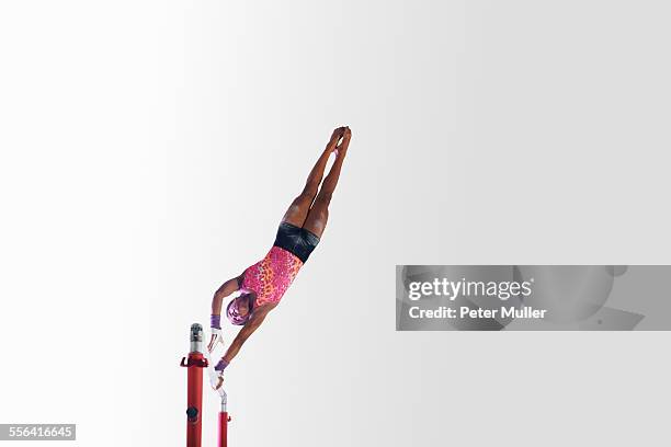 young gymnast performing on uneven bars - gymnastics equipment stock pictures, royalty-free photos & images