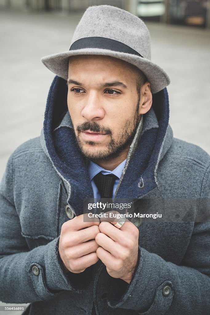 Businessman fastening his coat