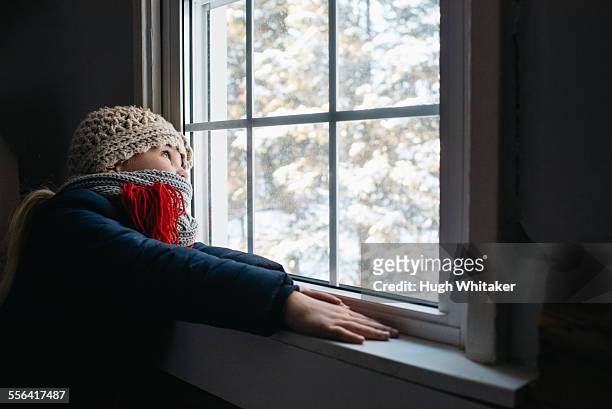 girl looking out of window - frost scheibe stock-fotos und bilder