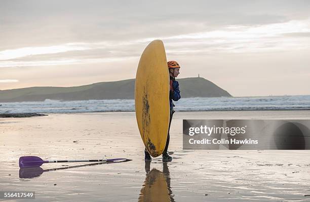 young woman on beach with sea kayak, polzeath, cornwall, england - polzeath photos et images de collection