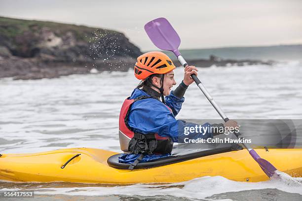 young woman sea kayaking - kayaking sul mare foto e immagini stock